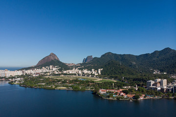 Fototapeta premium Aerial view from the city lake Lagoa Rodrigo de Freitas in Rio de Janeiro with the Two Brothers mountain and mountain range in the background and the jockey horse racing field in the foreground