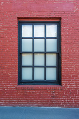Fototapeta na wymiar Black Window Frame in Red Brick Wall - Alley