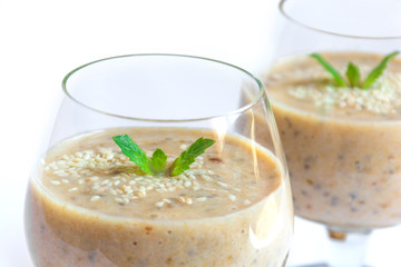 Vegetarian healthy banana smoothie in glass with mint isolated on white background