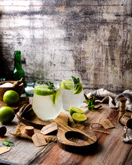 Two glasses of cold icy summer cocktail mojito with mint leaves and slices of lime
