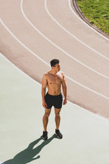 Fototapeta premium full length view of mixed race sportsman standing at stadium