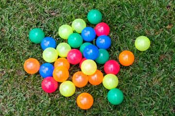  Multi-colored plastic balls on outdoor grass, group games for children.