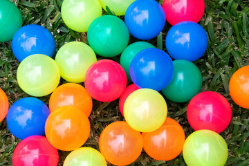  Multi-colored plastic balls on outdoor grass, group games for children.