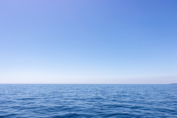Seascape with sea horizon and almost clear deep blue sky