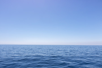 Fototapeta na wymiar Seascape with sea horizon and almost clear deep blue sky