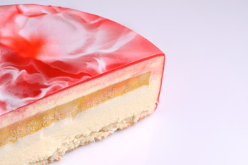 mousse cake with red icing on a white background