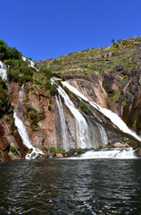 Colorful waterfall with rocks and vegetation. Ezaro, Spain.