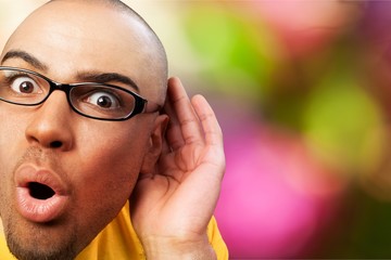 Listening handsome man wearing eyeglasses isolated on white