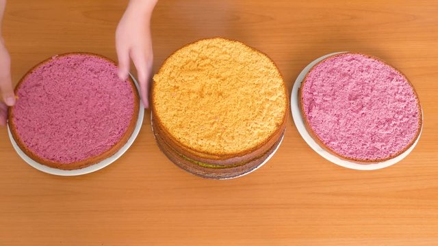 Women's hands shift the cakes of a different color biscuit in different plates