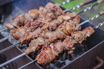 meat on skewers roasted over the coals.picnic in nature. preparation of a shish kebab.