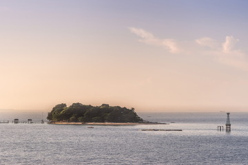 Obraz premium Makassar, Sulawesi, Indonesia - February 28, 2019: Closeup of Small green Samalona Island lost in blue sea under early. morning light.