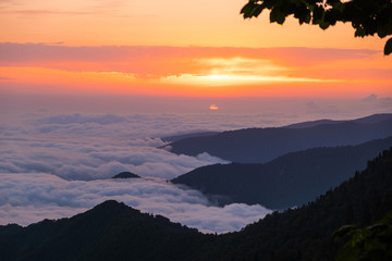 Sunset in the mountains. Large cumulus clouds over the mountains. Forest in the mountains. Evening light. Time to rest and enjoy. No people.