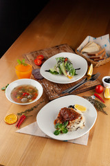 Set lunch menu in a restaurant: fish with steamed rice, light vegetable soup with meatballs and vegetarian spring roll