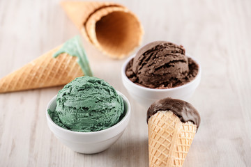Blueberry and pistachio ice cream with bowl on wooden background