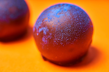 Chocolates with blue algae on colored background.
