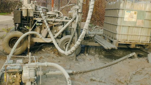 Strange dirty machine makes a well in clay