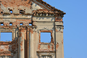 Ruins of ancient palace in Pruzhany, Belarus made of red brick with the blue sky instead of windows.