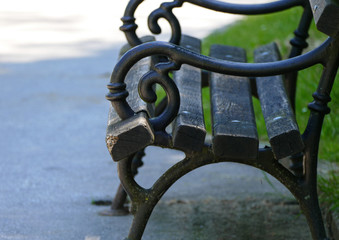 Old wooden bench in the park with metal ornament