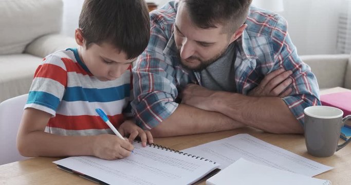 Father and son doing homework in notebook