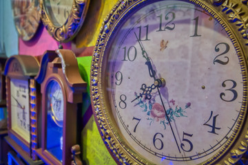 Antique clocks hanging on a multicolored wall