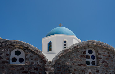 Fototapeta na wymiar Traditional Greek Orthodox church with bell tower in village of Oia on Santorini