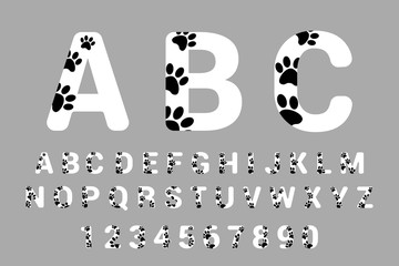 Font typography with animal paw prints. Isolated Alphabet with pet foot prints. White calligraphy and numbers with black dog paws.