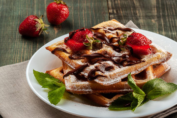 Viennese waffles with strawberries and mint are on the platter