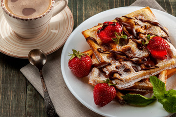 Viennese waffles with strawberries and mint are on the platter