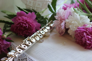 silver flute with a bouquet of pink peonies, color photography © olga_63