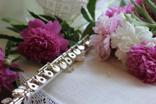 silver flute with a bouquet of pink peonies, color photography