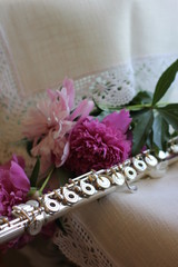 silver flute with a bouquet of pink peonies, color photography