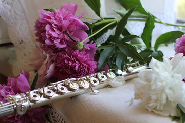 silver flute with a bouquet of pink peonies, color photography