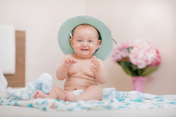 Beautiful and cute baby sitting on bed.