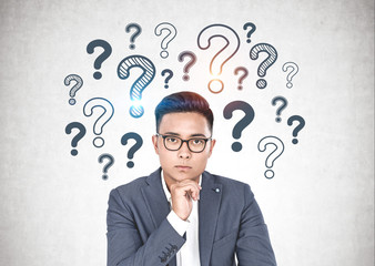 Asian businessman in glasses, question mark