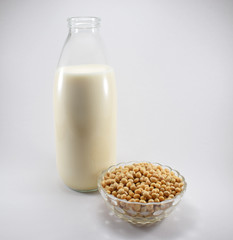 Botella de leche de soja y bol con granos de soja 