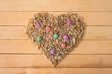 heart made of coarse sand on a wooden table