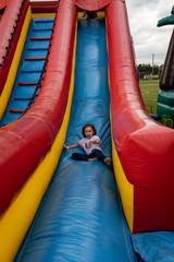 Fototapeta na wymiar Girl on slide in playground