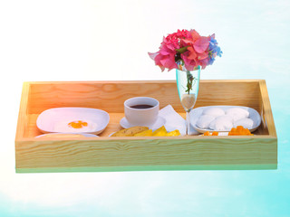 top view of breakfast in swimming pool on a floating table outside in a hotel.