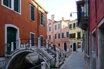 Fototapeta na wymiar A view of small canal and street of Venice with a private bridge