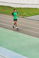 Obraz premium full length view of mixed race sportsman running at stadium
