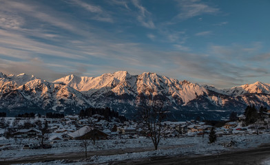 Panoramic view on Austrian village Tulfes near Innsbruck and Heiliger Apostel Thomas church in winter day at sunset.