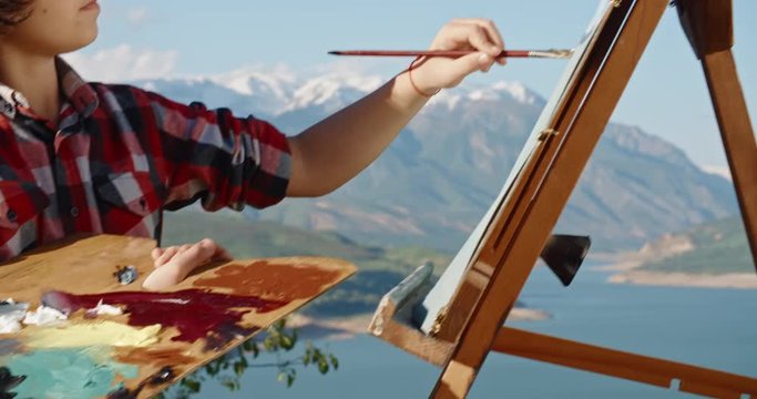 Young kid standing in front of easel, learning how to draw, creating a picture inspired by beautiful landscape, making first steps in fulfilling childhood dream - childhood memories, education concept