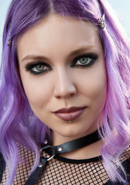 Close-up portrait of beautiful smiling gothic girl. Pastel goth with violet (pink) hair