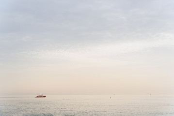 Motor boat floats on turquoise water in the sunset.