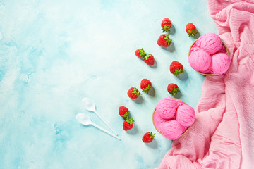 two portions raspberries ice cream in paper cup and pink napkin on mint colors background, top view