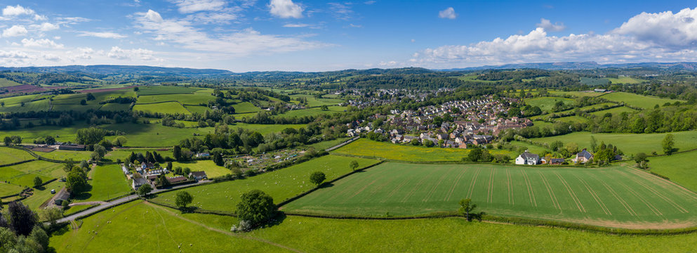 Aerial panoramic view of typical british farmers fields and some sheep, captured with the town of Usk in  the background in South Wales, UK