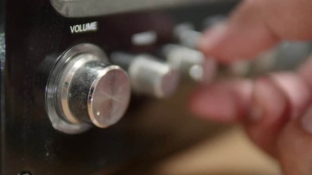 Hand adjusting volume control with blur adjust button for broadcasting and music concept. 4K, 25fps