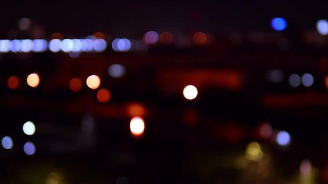 Bokeh background of skyscraper buildings in the city with lights and blurry at night colorful circles.4K, 25fps