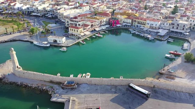 Aerial drone video of unique old picturesque Venetian port with old lighthouse in the heart of famous city of Rethymno at sunset, Crete island, Greec