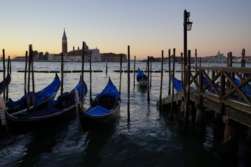 Gondole Stazio Danieliin on sunrise, with Church of San Giorgio Maggiore on the background.